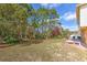 Lush, tree-filled backyard with a grill and brick patio, perfect for relaxation and outdoor activities at 2359 Gimlet Ave, Spring Hill, FL 34608