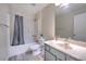 Neutral bathroom features tub and shower with gray curtain and white sink and vanity at 2359 Gimlet Ave, Spring Hill, FL 34608