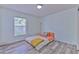 Bright bedroom showcasing modern flooring, a cozy bed, and a large window at 2359 Gimlet Ave, Spring Hill, FL 34608