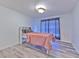 Bedroom showcasing cozy furnishings, including a bed with a pink cover and modern flooring at 2359 Gimlet Ave, Spring Hill, FL 34608
