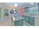 Kitchen featuring an island, stainless appliances and green cabinets with arched doorways leading to other rooms at 2359 Gimlet Ave, Spring Hill, FL 34608