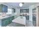 Kitchen with stainless appliances, green cabinets and a kitchen island topped with a bowl of fruit at 2359 Gimlet Ave, Spring Hill, FL 34608