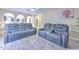 Living room featuring arched doorways to other rooms and two reclining sofas atop a white plush rug at 2359 Gimlet Ave, Spring Hill, FL 34608