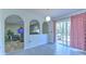 An open-concept living room featuring arched doorways to other rooms and a sliding glass door to the outside at 2359 Gimlet Ave, Spring Hill, FL 34608