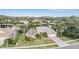 Aerial view showcasing the home, lush landscaping, and a serene lake at 3360 Hickorywood Way, Tarpon Springs, FL 34688