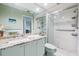 Well-lit bathroom features a walk-in shower, granite counters, and light blue cabinets at 3360 Hickorywood Way, Tarpon Springs, FL 34688