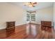 Spacious bedroom featuring hardwood floors, two windows, and furnishings at 3360 Hickorywood Way, Tarpon Springs, FL 34688