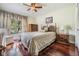 Cozy bedroom with wooden floors, natural light, and comfortable furnishings at 3360 Hickorywood Way, Tarpon Springs, FL 34688