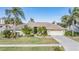 Single-story house with light green exterior, landscaping, and a two-car garage at 3360 Hickorywood Way, Tarpon Springs, FL 34688
