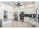 Bright kitchen featuring stainless steel appliances, granite countertops, and white cabinetry at 3360 Hickorywood Way, Tarpon Springs, FL 34688