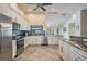 Bright kitchen featuring stainless steel appliances, granite countertops, and white cabinetry at 3360 Hickorywood Way, Tarpon Springs, FL 34688