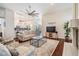 Cozy living room with fireplace, hardwood floors, and open layout to kitchen at 3360 Hickorywood Way, Tarpon Springs, FL 34688