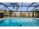 Sparkling screened-in pool with relaxing views of the surrounding landscape and waterfront at 3360 Hickorywood Way, Tarpon Springs, FL 34688