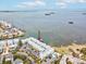 Aerial view of waterfront condo building with a dock and parking at 464 N Paula Dr # 322, Dunedin, FL 34698