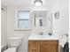 Bright bathroom with wood vanity, toilet, and mirrored medicine cabinet at 464 N Paula Dr # 322, Dunedin, FL 34698