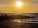 Stunning sunset over the ocean with rocky shoreline at 464 N Paula Dr # 322, Dunedin, FL 34698