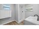 Updated bathroom with shower, gray vanity, and wood-look floors at 4923 Azalea Dr, New Port Richey, FL 34652