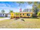 Yellow Ranch style home with landscaped lawn and American flag at 1010 59Th N Ave, St Petersburg, FL 33703