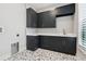 Laundry room with dark cabinetry, quartz countertops, and patterned flooring at 10639 Ruffino Ct, Trinity, FL 34655