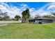 Large grassy backyard with a screened pool and trees at 11303 Leprechaun Dr, Riverview, FL 33569