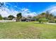 Spacious backyard with a view of the house and screened patio at 11303 Leprechaun Dr, Riverview, FL 33569