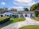 Single-story home with a brown roof, white exterior, and landscaped yard at 11303 Leprechaun Dr, Riverview, FL 33569