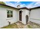 White stucco exterior with a brown door, window, and hose at 11303 Leprechaun Dr, Riverview, FL 33569