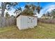 Small metal storage shed with double doors in backyard at 11303 Leprechaun Dr, Riverview, FL 33569