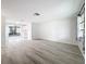 Bright living room featuring sleek wood floors and fresh paint, leading into a sunroom at 11801 104Th St, Largo, FL 33773