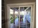 View of backyard through sliding glass door, showing patio and pergola at 143 44Th N Ave, St Petersburg, FL 33703