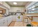 Kitchen with white cabinets, stove, microwave and small table at 19029 Us Highway 19 N # 5-1, Clearwater, FL 33764
