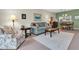 Living room with floral armchair, sofa, and view to dining area at 19029 Us Highway 19 N # 5-1, Clearwater, FL 33764