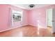 Pink bedroom with wood flooring and window overlooking yard at 2405 Lema Dr, Spring Hill, FL 34609