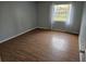 Simple bedroom with wood-look flooring and a window with curtains at 2850 Somerset Park Dr # 102, Tampa, FL 33613