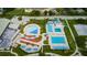 Aerial view of an aquatic center featuring pools and splash pad areas with colorful umbrellas and lounge chairs at 5524 Kentucky Ave, New Port Richey, FL 34652