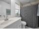 Bright bathroom with a vanity, framed mirror, and a tiled shower at 5524 Kentucky Ave, New Port Richey, FL 34652