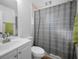 Bathroom with single vanity, framed mirror, and a shower with patterned curtain at 5524 Kentucky Ave, New Port Richey, FL 34652