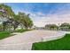 Open community event space with a brick surface bordered by green lawns and mature oak trees at 5524 Kentucky Ave, New Port Richey, FL 34652