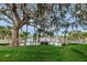 Wooden footbridge over a pond with mature trees, Spanish moss, and a green lawn at 5524 Kentucky Ave, New Port Richey, FL 34652