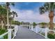 Wooden footbridge over a pond with palm trees and a fountain in the distance at 5524 Kentucky Ave, New Port Richey, FL 34652