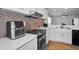 Kitchen featuring white countertops, stainless steel appliances, and light brown tile backsplash at 5524 Kentucky Ave, New Port Richey, FL 34652