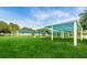 Open community park showcasing shade structures on a large green lawn under a bright blue sky at 5524 Kentucky Ave, New Port Richey, FL 34652