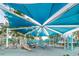 Community playground featuring slides, climbing structures, and a shaded canopy over a safety surface at 5524 Kentucky Ave, New Port Richey, FL 34652