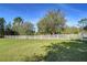 Serene pasture with a white fence, large oak trees, and lush green grass at 8345 Shenandoah Run, Wesley Chapel, FL 33544