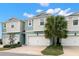 Two-story townhouses with attached garages and landscaping at 1003 Starboard Ct, Oldsmar, FL 34677