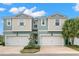 Two-story townhome with attached garages, light-blue and beige exterior, and landscaping at 1003 Starboard Ct, Oldsmar, FL 34677