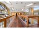 Long hallway with dark hardwood floors and wooden railings at 18409 Tyler Rd, Odessa, FL 33556