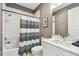 Clean bathroom with white vanity, bathtub, and striped shower curtain at 20001 Gulf Blvd # 501, Indian Shores, FL 33785