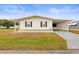 Front view of a white single-wide manufactured home with carport at 36925 Kiowa Ave, Zephyrhills, FL 33542