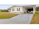 White single-wide manufactured home with carport and landscaped lawn at 36925 Kiowa Ave, Zephyrhills, FL 33542